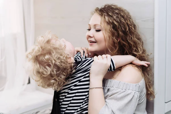 Curly young mother playing with her little baby boy, laughing, having fun — Stock Photo, Image