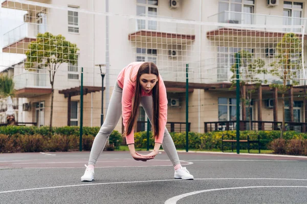 Atletische jong meisje kneden van spieren voor opleiding op een sportveld, die zich bezighouden met fitness — Stockfoto