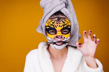 yüzünde bir maske leopar yüzü olan bir hayvan gibi kafa onun growls üzerine bir havlu ile garip bir genç kız