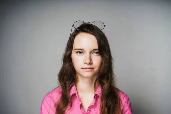 Jovem triste em uma camisa rosa e óculos cansados de trabalho — Fotografia de Stock