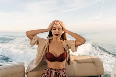 yaz giysileri lüks ve zengin bir kadın onu pahalı yat üzerinde oturur, adalarına tatile yelken