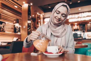 rahat bir oryantal kafe, içecek çay ve gülümser güzel Arap kız başında başörtüsü ile akşam