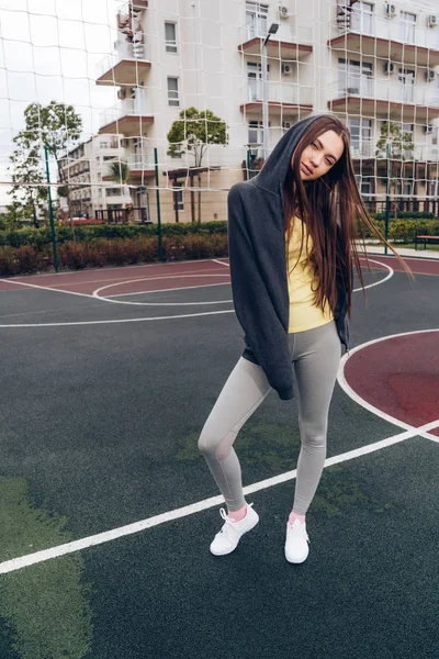 Впевнена струнка дівчина позує на спортивному полі на відкритому повітрі, веде активний і здоровий спосіб життя — стокове фото
