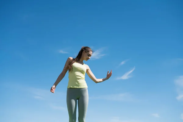 Štíhlé silné děvče zabývá jóga pod modrou oblohu, hodně síly a energie — Stock fotografie