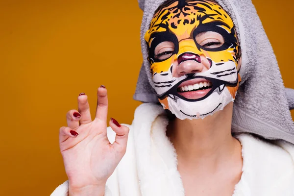 Riéndose jovencita con una toalla en la cabeza sonriendo, en su cara una máscara con una cara de leopardo —  Fotos de Stock