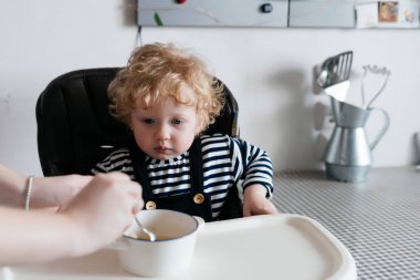 kıvırcık küçük çocuk sandalyesi mutfakta oturup ailece Kahvaltı