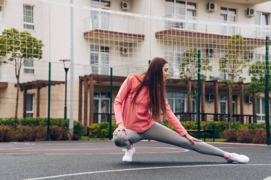 ince bir genç kız kaslar Spor zemin üzerinde kneads, esnek ve güçlü olmak istiyor
