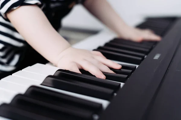 A young child learns to play the piano, has fun and studies the world — Stock Photo, Image