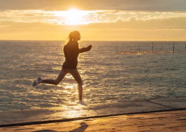 Maratonu için hazır Başlarken setin batımında, koşan atletik hızlı genç kız