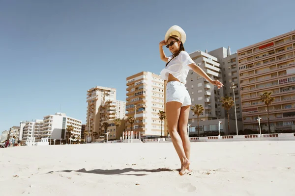Chica con un sombrero baila en la playa —  Fotos de Stock