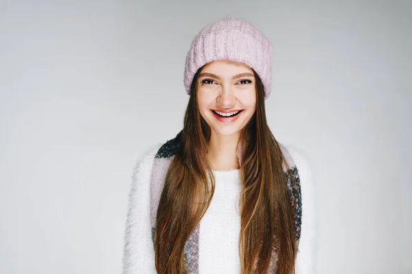 Cheerful brunette in a knitted hat smiles amiably — Stock Photo, Image