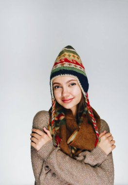 Hoş bir gülümseme ile kollarını göğsünde kavuşturan kalın elbiseli kız. parlak stüdyo