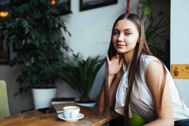 Bir fincan çay içmek için bir kafede molada olan öğrenci.