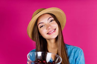 Stüdyoda yaz katibi gururla kiraz hasadını gösteriyor.