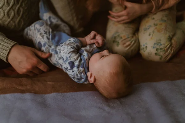 A família inclinou-se sobre o bebê deitado de costas — Fotografia de Stock
