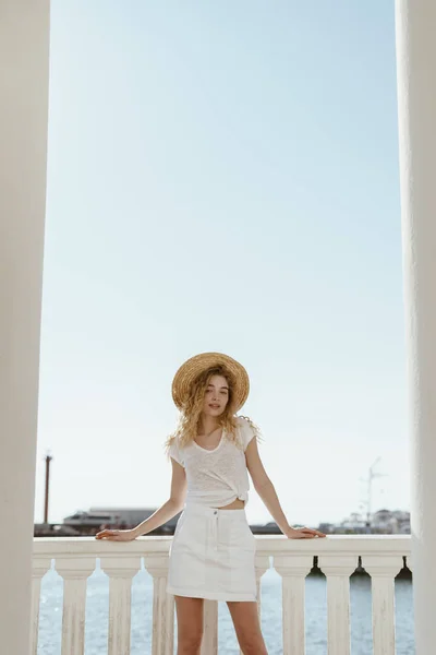 Göndör szőke fehér ruhák hátterében fehér oszlopok — Stock Fotó