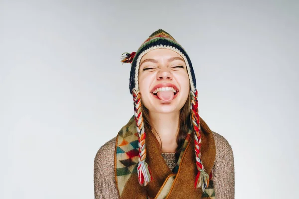 Mädchen im Pullover lacht, hebt das Kinn und streckt die Zunge heraus, neckt — Stockfoto