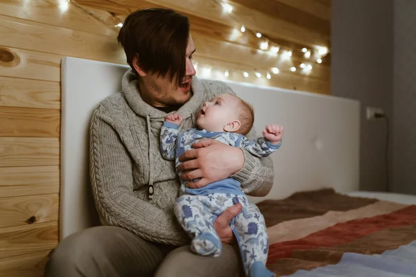 멋진 머리를 하고 있는 어린 아버지 가손에 아기를 안고 있다 — 스톡 사진