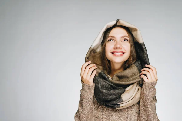 Die Augen der Mädchen strahlen vor Freude mit einem schönen Lächeln in einem warmen Schal und Pullover gekleidet — Stockfoto