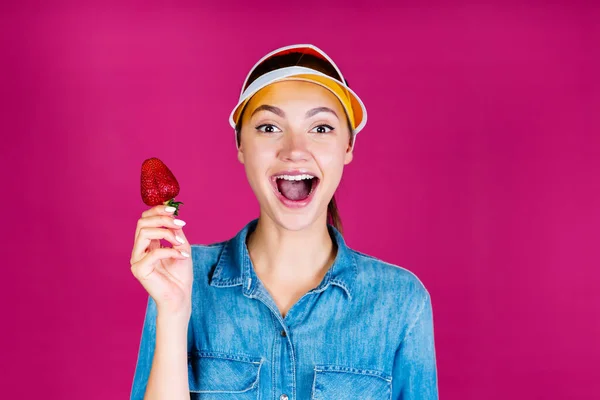 ハハッ!ビジターの女の子がイチゴを手に持ってるって。背景ピンク — ストック写真
