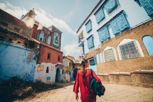 Magnífica vista de una chica caminando por la calle en la ciudad azul de Marruecos vista desde la parte posterior — Foto de Stock