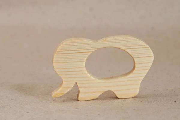 A wooden handmade toy is a rodent (for teething in babies) in the form of an animal with a pronounced wood texture