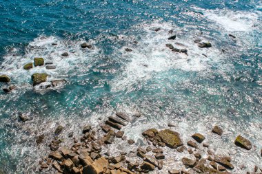 Sörf, dalgalar kayalara üstten görünüm acele.