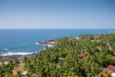 Sri Lanka. Dondra. Deniz feneri üst görünümden turkuaz deniz (okyanus), kayalık Plajı, kum plaj, yeşil avuç içi kırmızı çatılar evleri ve jig gemilerde döşenir..