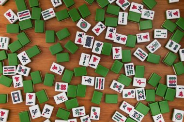 Mahjong kahverengi ahşap arka plan üzerinde beyaz-yeşil çini. Boş yer yok.