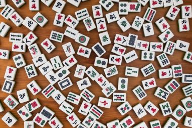 Mahjong kahverengi ahşap arka plan üzerinde beyaz-yeşil çini. Boş yer yok.