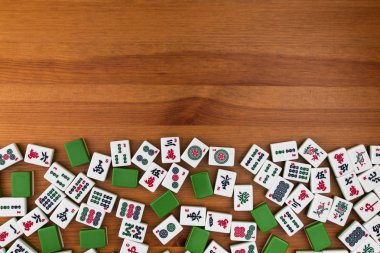 Mahjong kahverengi ahşap arka plan üzerinde beyaz-yeşil çini. Boş alanı yukarıdaki