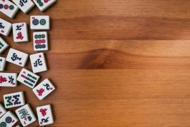 Mahjong kahverengi ahşap arka plan üzerinde beyaz-yeşil çini. Boş yere değil.