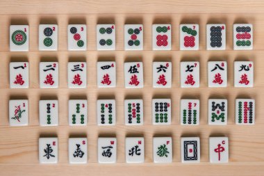 White-green tiles for mahjong on a brown wooden background. clipart
