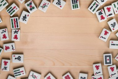 Mahjong hafif kahverengi ahşap arka plan üzerinde beyaz-yeşil çini. Ortasındaki boş alanı