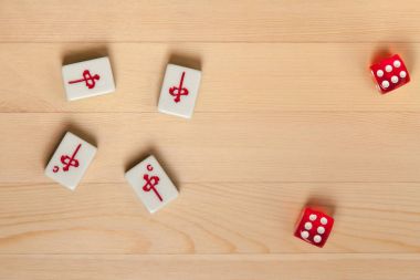 Kırmızı zar ve kemiklere mahjong hafif kahverengi ahşap arka plan üzerinde (kiremit).
