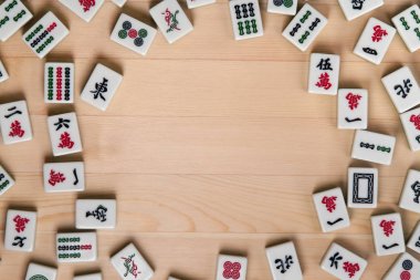 Mahjong hafif kahverengi ahşap arka plan üzerinde beyaz-yeşil çini. Ortasındaki boş alanı