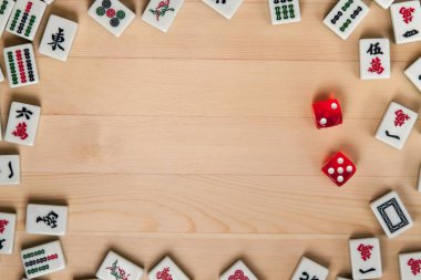 Kırmızı zar ve kemiklere mahjong hafif kahverengi ahşap arka plan üzerinde (kiremit).
