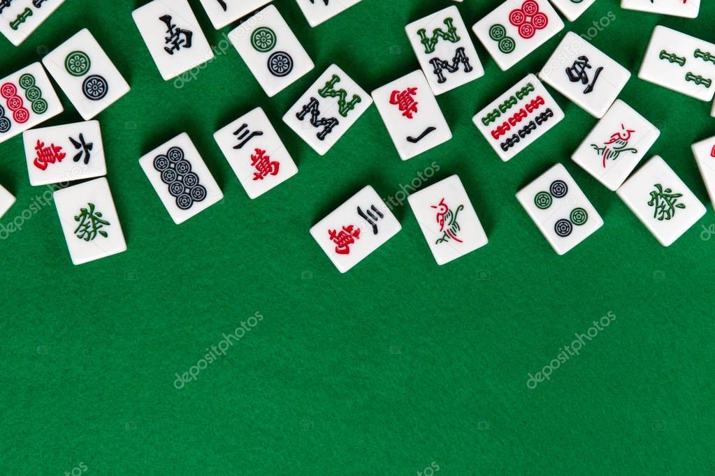 White-green tiles for mahjong on on green cloth background. Emty space from below