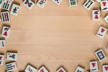 Mahjong hafif kahverengi ahşap arka plan üzerinde beyaz-yeşil çini. Ortasındaki boş alanı