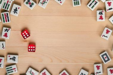Kırmızı zar ve kemiklere mahjong hafif kahverengi ahşap arka plan üzerinde (kiremit).