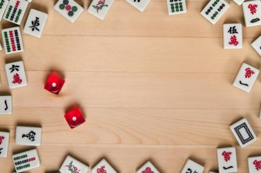 Kırmızı zar ve kemiklere mahjong hafif kahverengi ahşap arka plan üzerinde (kiremit).