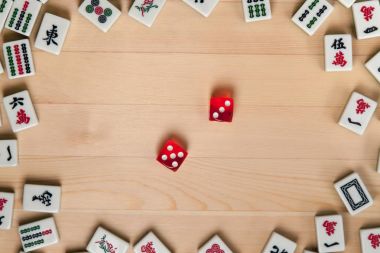 Kırmızı zar ve kemiklere mahjong hafif kahverengi ahşap arka plan üzerinde (kiremit).