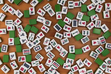 Mahjong kahverengi ahşap arka plan üzerinde beyaz-yeşil çini. Boş yer yok.