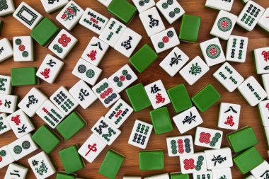 Mahjong kahverengi ahşap arka plan üzerinde beyaz-yeşil çini. Boş yer yok.