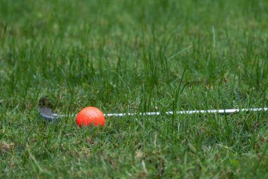 Turuncu golf topu ve atıcı yeşil çimenlerin üzerinde