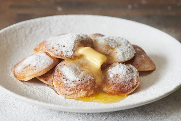 Dutch Mini Pancakes (Poffertjes). Fluffy mini pancakes that are served with a mess of powdered sugar and butter.