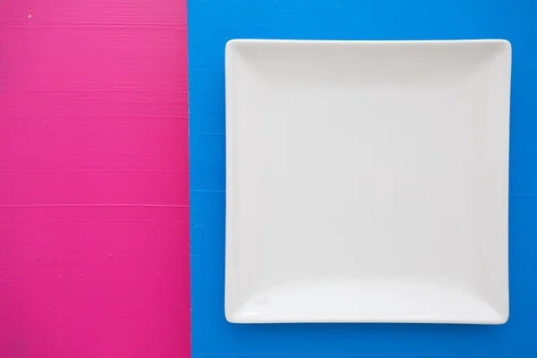 파란색과 분홍색 배경, squar 위에 빈 흰색 세라믹 접시 — 스톡 사진