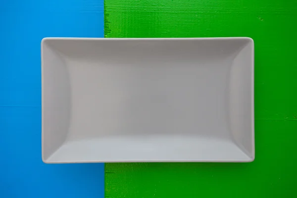 파란과 녹색 배경에, recta에 빈 회색 세라믹 접시 — 스톡 사진