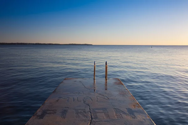 Yalnız beton rıhtım city Beach gün batımında, Slovenya — Stok fotoğraf