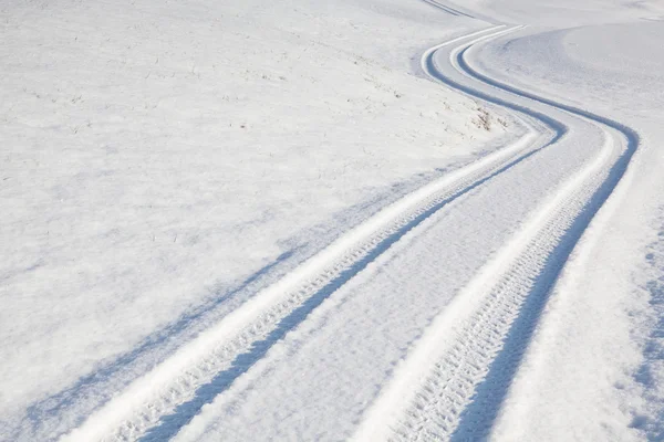 Carro faixa de pneu na estrada de inverno — Fotografia de Stock